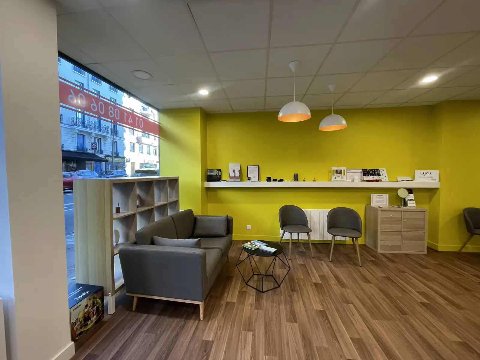 Audition Marc Boulet salon d'accueil avec mobilier moderne, murs verts lumineux, espace confortable pour les clients, ambiance chaleureuse et professionnelle pour auditions musicales.